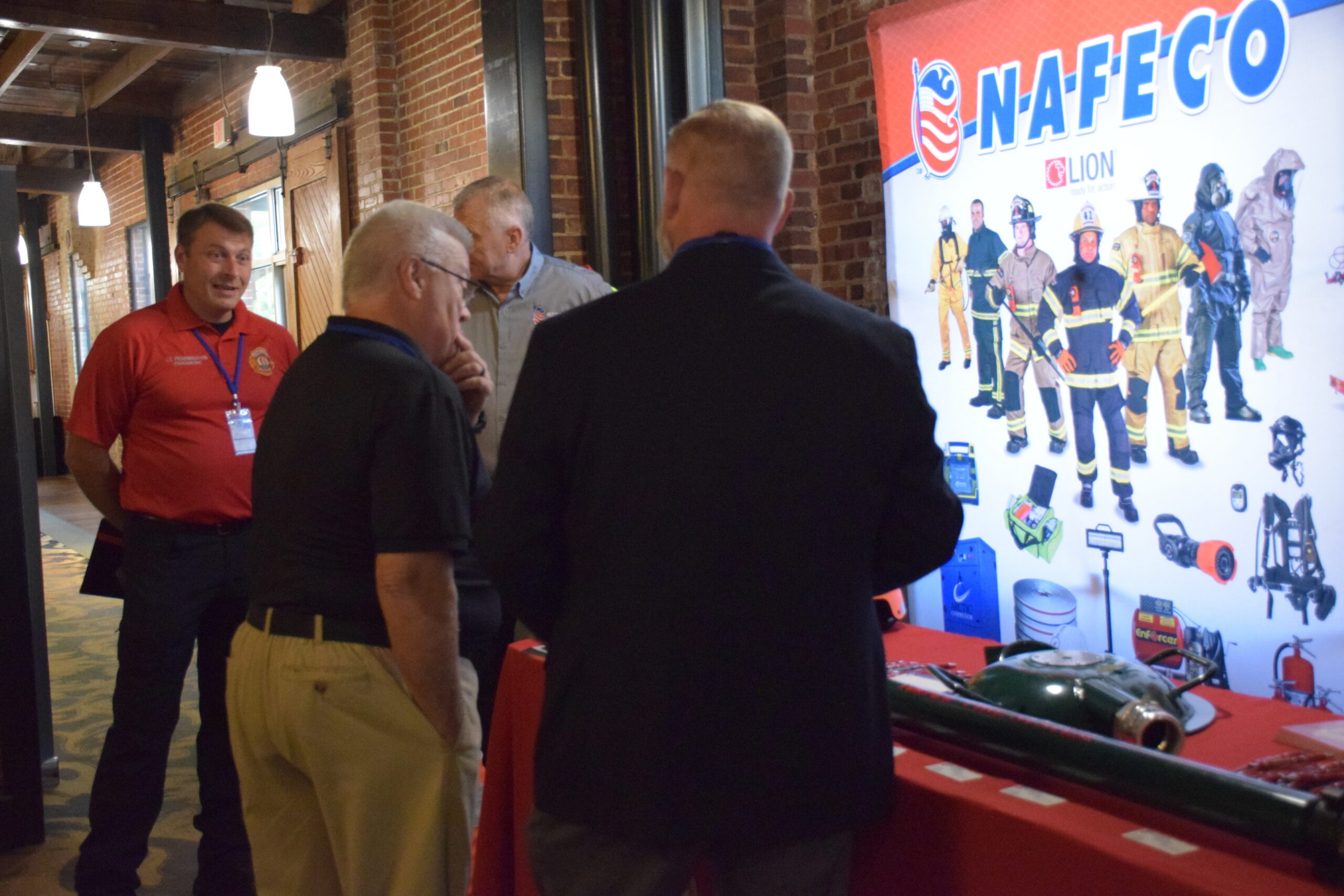 Conference attendee speaking with conference exhibitors at their exhibition stand during the 2024 TIME Task Force Conference.