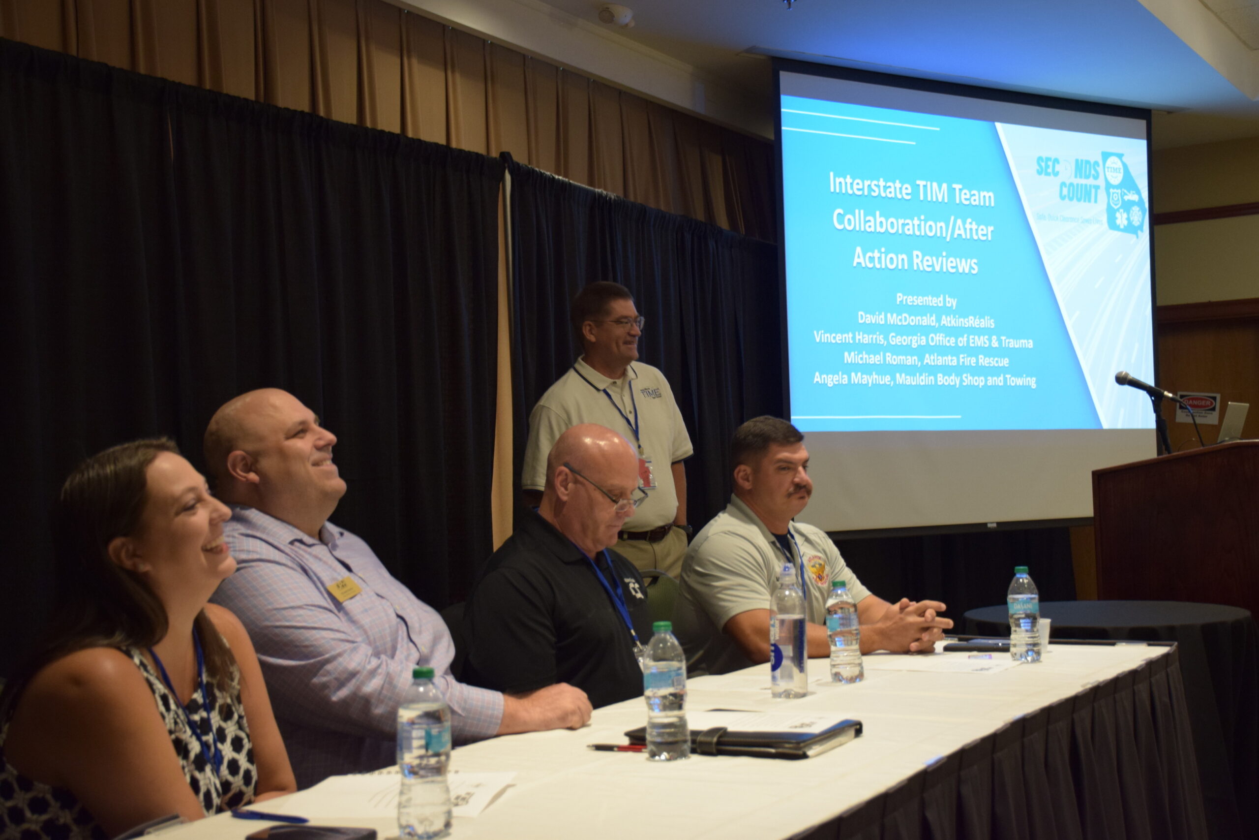 A panel of four speakers smile and laugh together as they speak during a 2024 TIME Task Force Conference session.