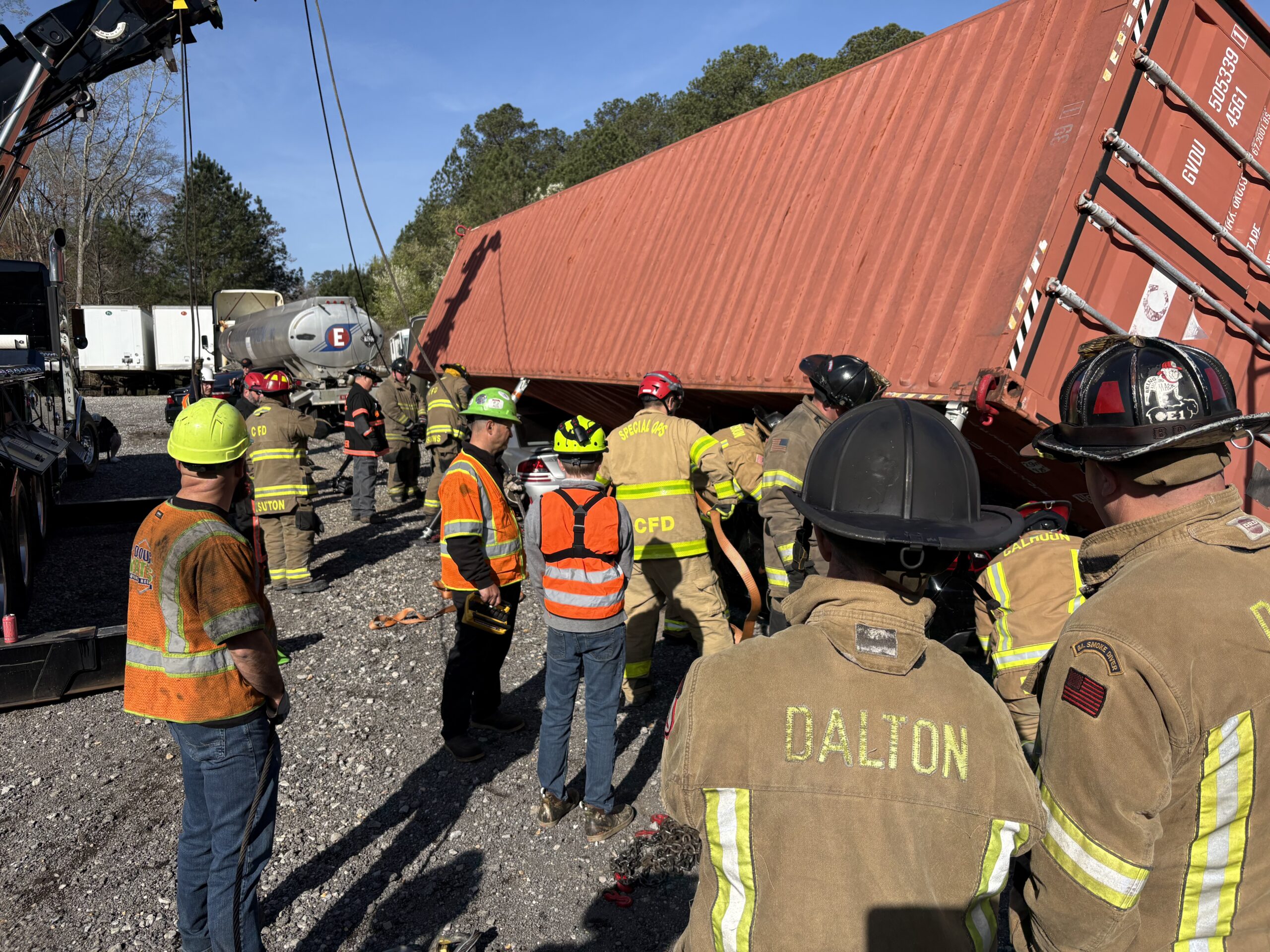 Responders at a Heavy Wrecker Technical Rescue Training, watching as a heavy wrecker tow truck lifts a box car.